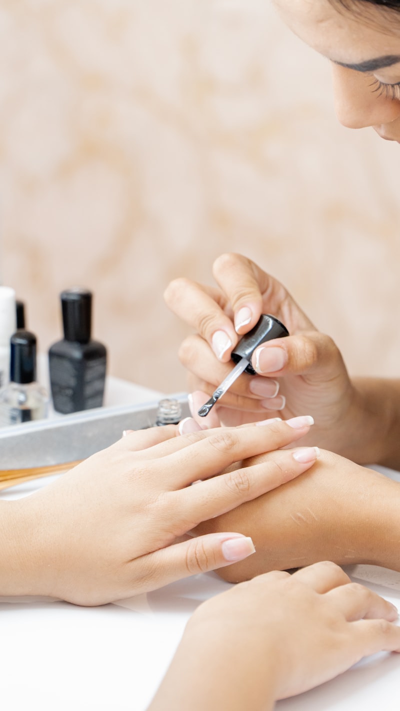 A therapist applying nail polish during a manicure